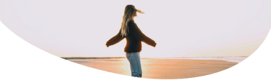 Silhouette Image of a female in the distance wearing a baseball cap, with the sun behind her