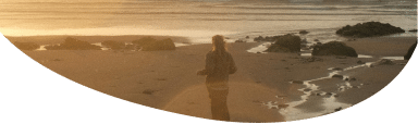 Image of a person standing on a beach looking out to sea