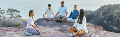 A group of people sitting in a circle on the top of a mountain, as if for the Radical Forgiveness Healing Ceremony program