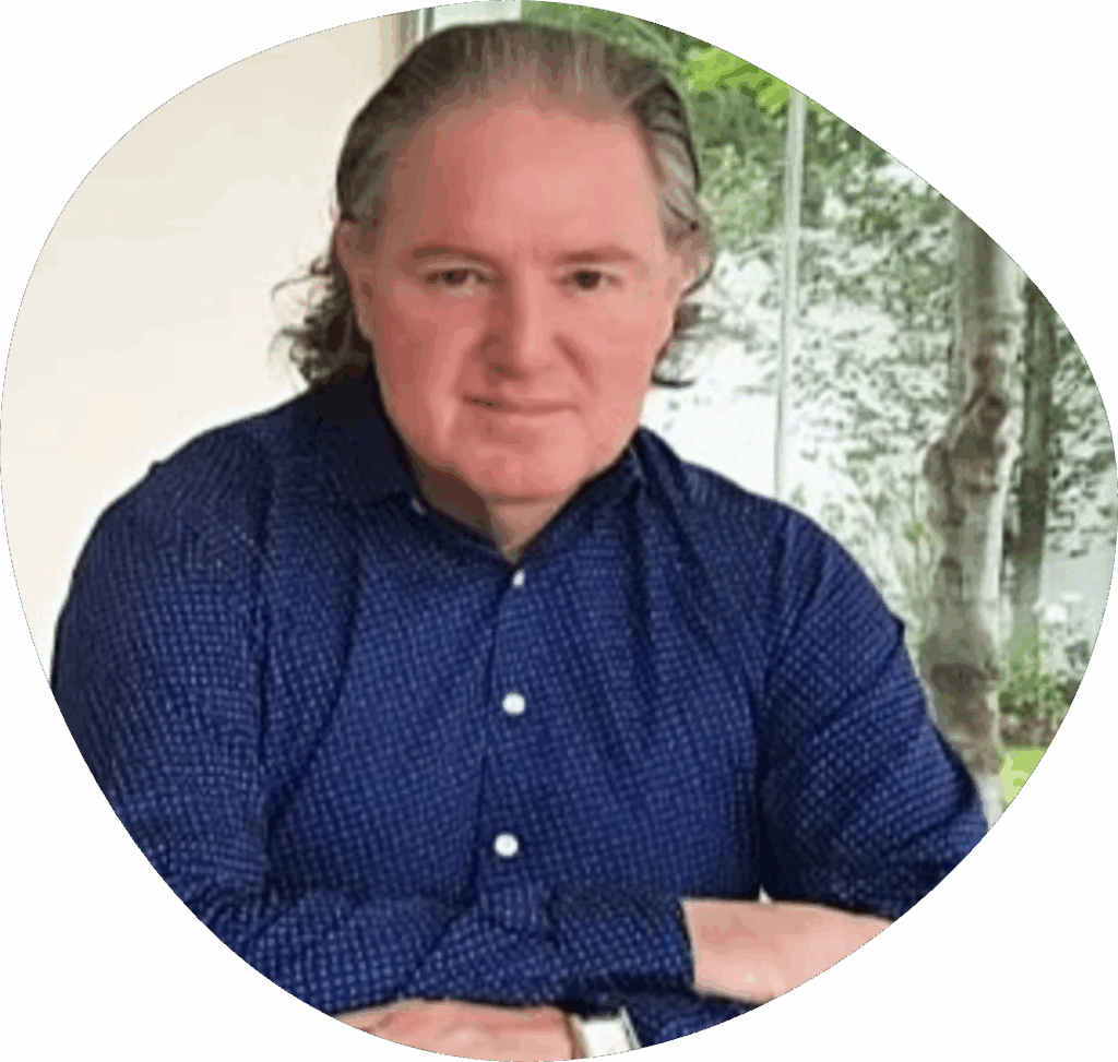 Godfrey O'Flaherty, CEO of the IIRFL and Global Custodian of Radical Forgiveness, sitting at a desk wearing a smart shirt