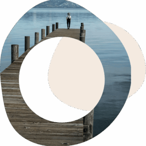 Abstract circles with the image of someone standing alone at the end of a jetty looking out onto a lake