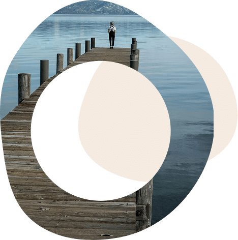 Abstract circles with the image of someone standing alone at the end of a jetty looking out onto a lake