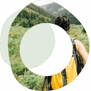 Abstract circles image of a woman wearing a backpack walking towards mountains