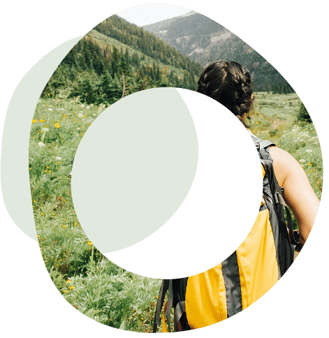 Abstract circles image of a woman wearing a backpack walking towards mountains