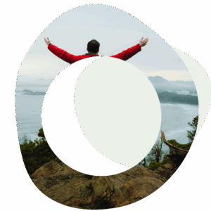 Abstract image of a person with their arms outstretched in the air and they are looking towards a lake