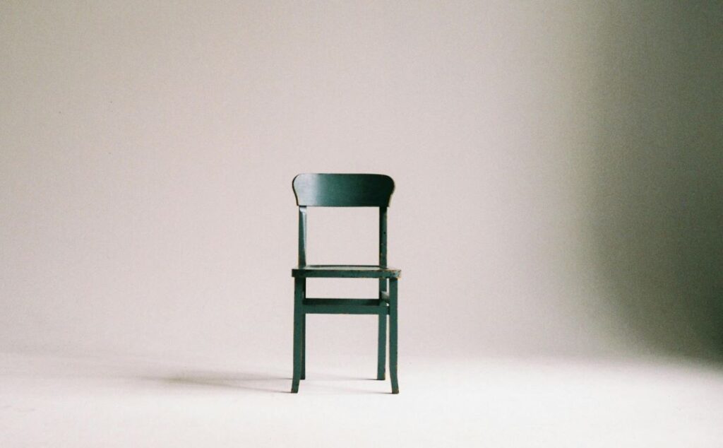 A simple green dining chair in an empty room